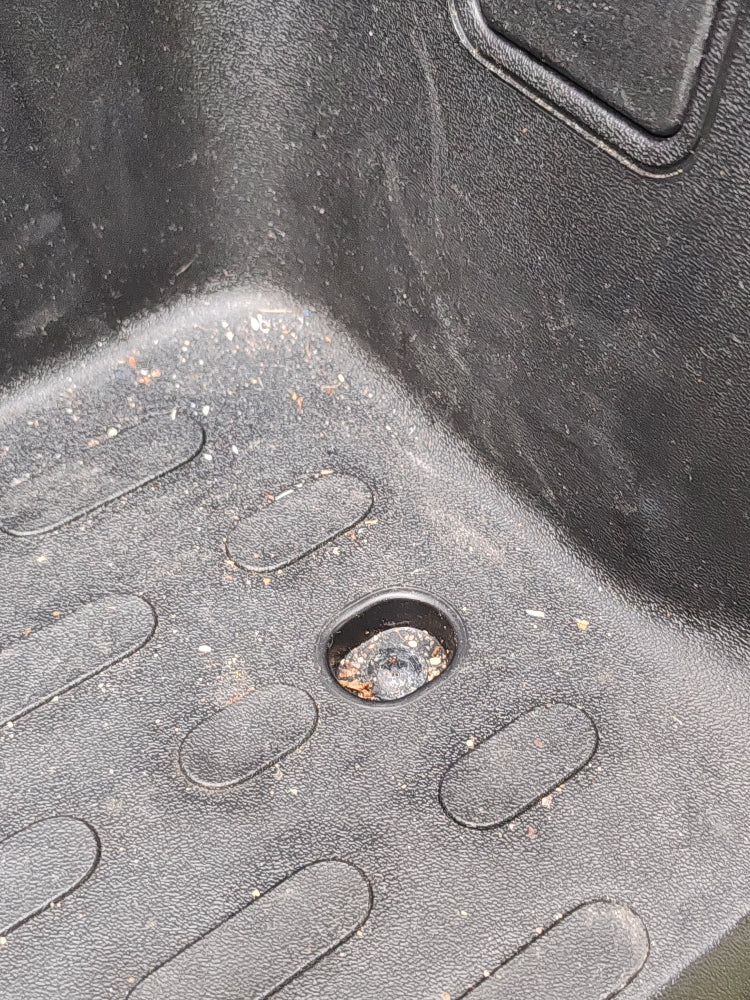 Offene Schraubenvertiefung mit angesammeltem Schmutz in der Fahrerhaus-Trittstufe